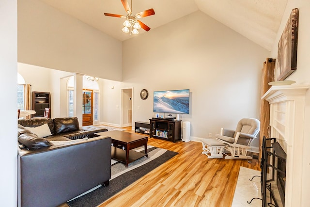 living room featuring ceiling fan, high vaulted ceiling, and light hardwood / wood-style floors