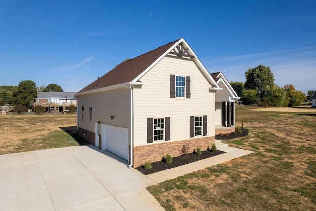 view of side of home featuring a garage and a lawn