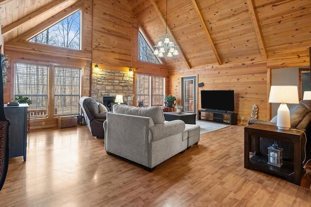 living room with a stone fireplace, wooden walls, wood ceiling, and light hardwood / wood-style flooring