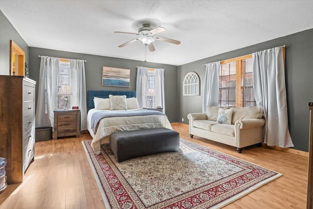 bedroom featuring ceiling fan, hardwood / wood-style floors, and a textured ceiling