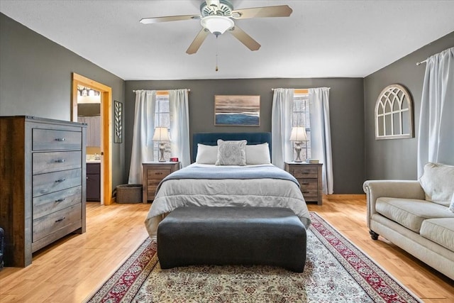 bedroom featuring ceiling fan, multiple windows, and light hardwood / wood-style flooring