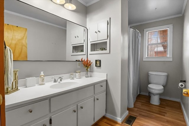 bathroom with vanity, wood-type flooring, ornamental molding, and toilet