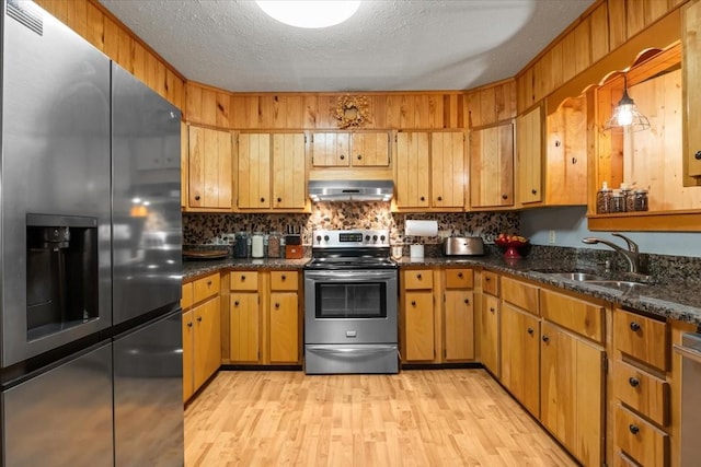 kitchen with sink, light hardwood / wood-style flooring, stainless steel appliances, ventilation hood, and a textured ceiling