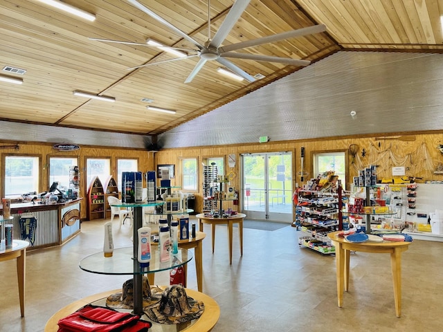 interior space with lofted ceiling, wooden ceiling, ceiling fan, and wood walls