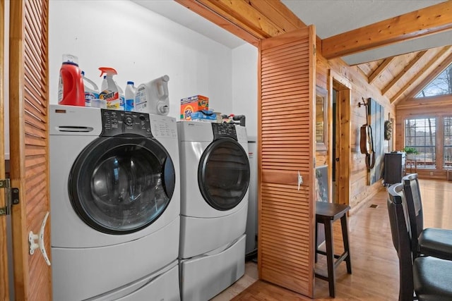 laundry area featuring washing machine and dryer and light hardwood / wood-style flooring