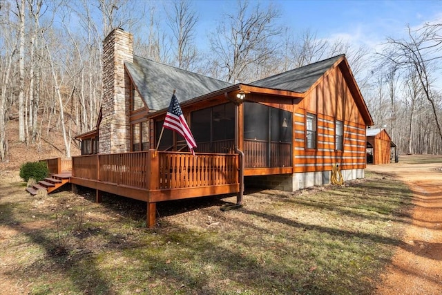 rear view of house with a sunroom and a deck