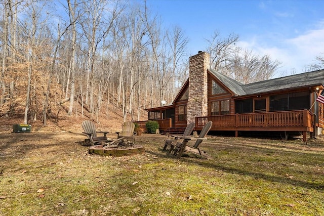 back of house with a yard, a fire pit, and a deck