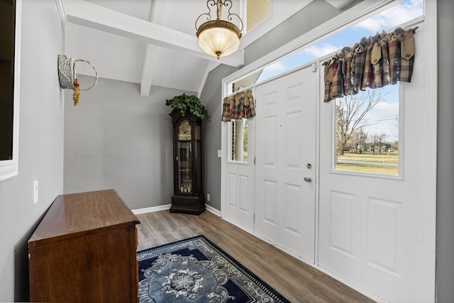 foyer entrance with hardwood / wood-style flooring and lofted ceiling with beams