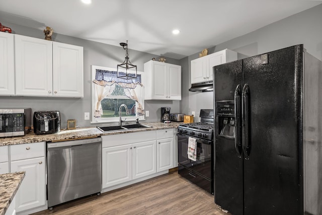 kitchen with hanging light fixtures, white cabinetry, sink, and black appliances