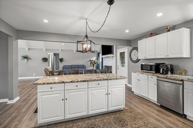 kitchen with white cabinets, a center island, stainless steel appliances, and decorative light fixtures