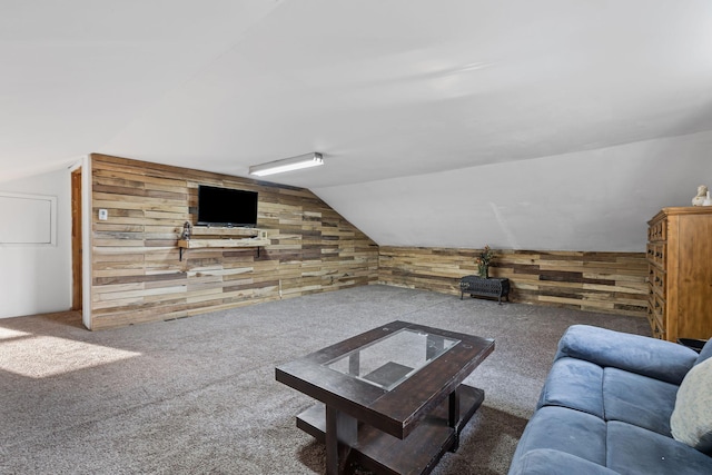 carpeted living room featuring lofted ceiling and wooden walls