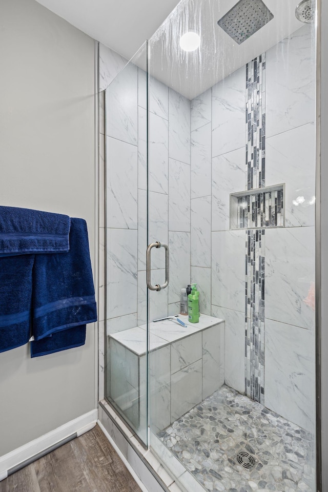 bathroom with wood-type flooring and a shower with shower door