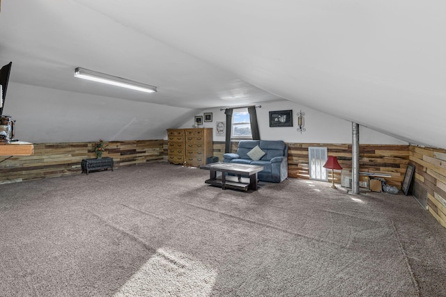 bonus room with carpet, vaulted ceiling, and wood walls