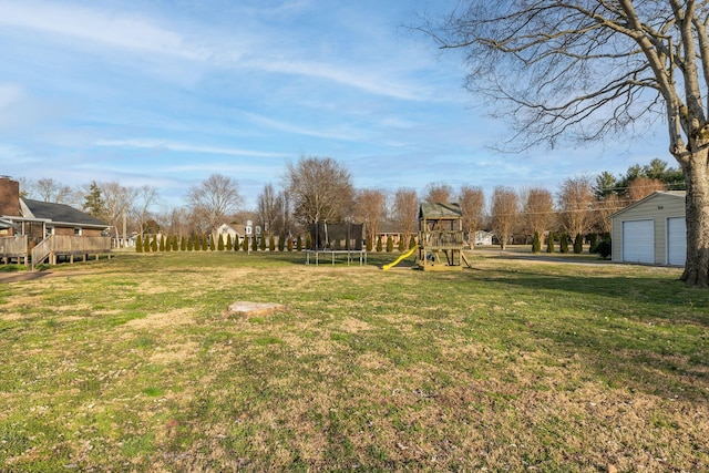 view of yard with a playground, a trampoline, and a garage