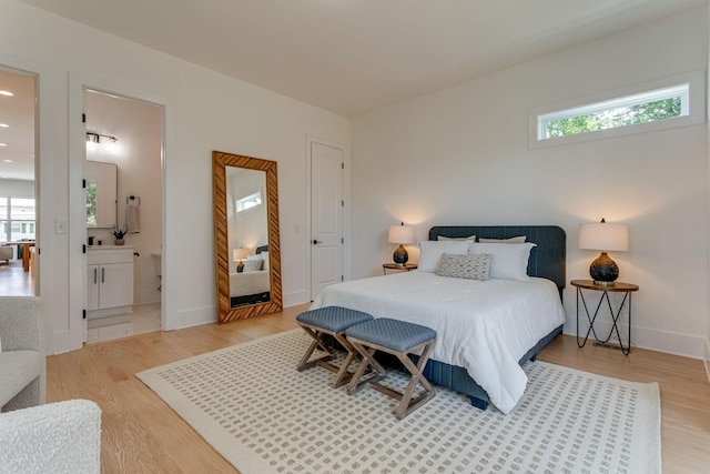 bedroom featuring multiple windows, light hardwood / wood-style flooring, and ensuite bathroom