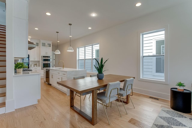 dining space featuring sink and light hardwood / wood-style floors