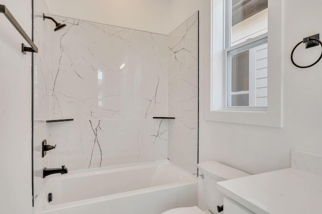 full bathroom featuring tiled shower / bath combo, vanity, and toilet