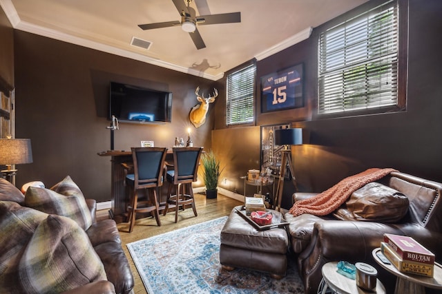 cinema with ornamental molding, wood-type flooring, and ceiling fan