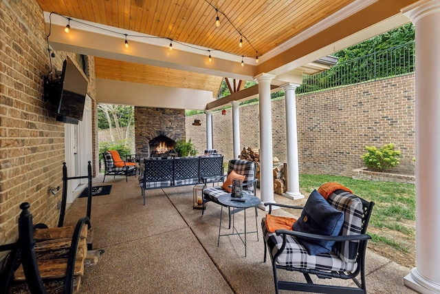 view of patio with an outdoor living space with a fireplace