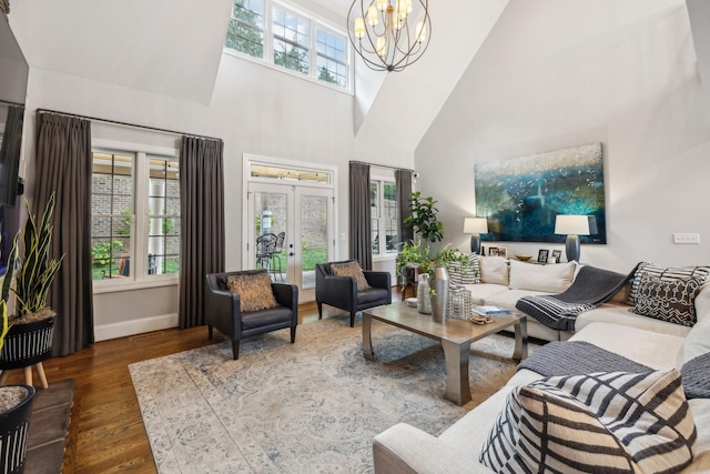 living room with a wealth of natural light, a notable chandelier, dark hardwood / wood-style flooring, and french doors