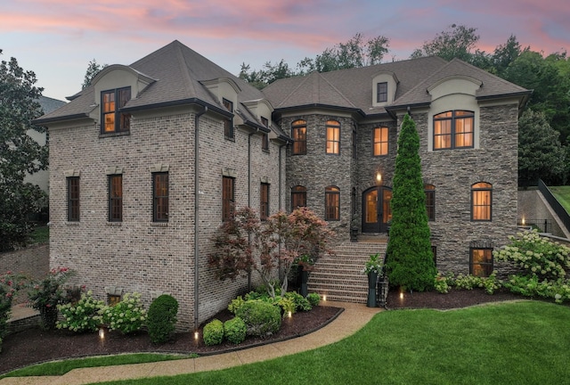 french provincial home with a lawn and french doors