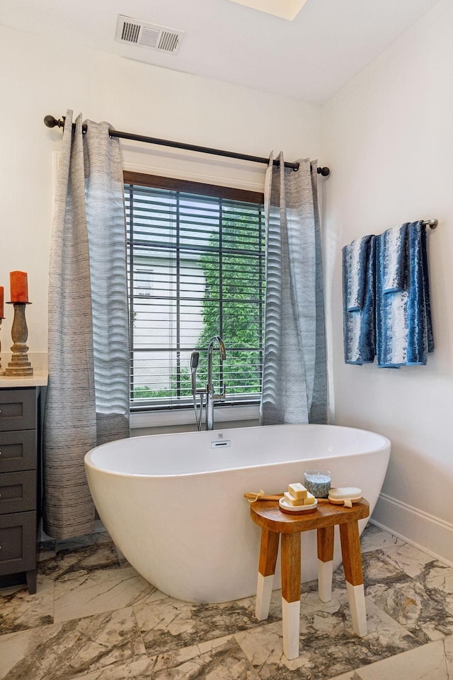 bathroom featuring vanity and a washtub