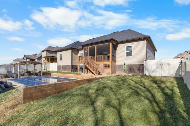 rear view of house with a sunroom, a covered pool, a yard, and a pergola