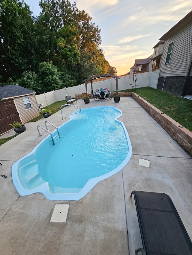 pool at dusk featuring a pergola, a patio area, and a storage unit