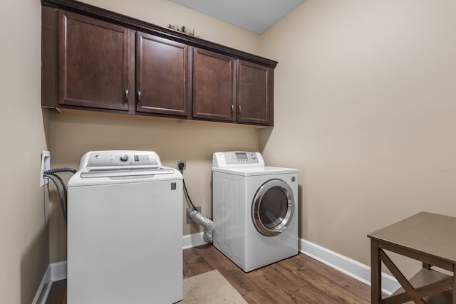 laundry room with separate washer and dryer, dark wood-type flooring, and cabinets