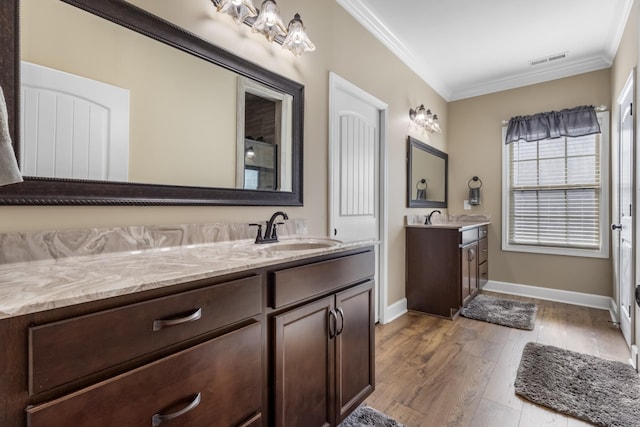 bathroom with vanity, crown molding, and hardwood / wood-style flooring