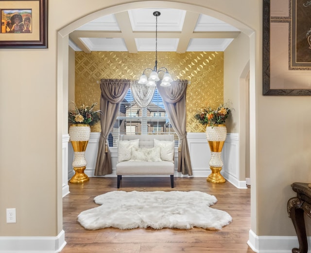 living area with coffered ceiling, crown molding, a chandelier, hardwood / wood-style flooring, and beam ceiling