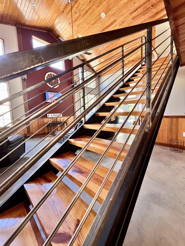 stairs featuring wood ceiling, vaulted ceiling, and wood walls