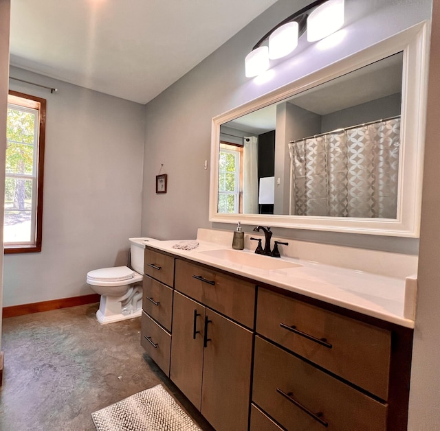 bathroom featuring vanity, toilet, and a healthy amount of sunlight