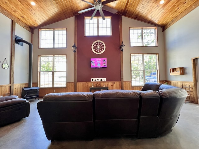 living room featuring wood ceiling, wood walls, and a wood stove