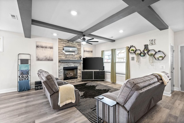 living room featuring a fireplace, light hardwood / wood-style flooring, beamed ceiling, and ceiling fan