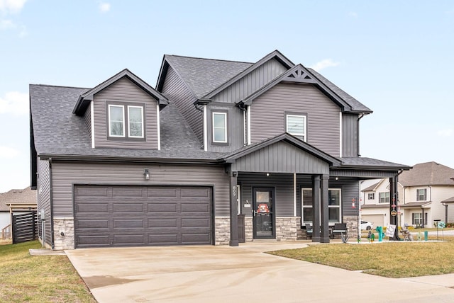 craftsman inspired home with a garage, a front lawn, and covered porch