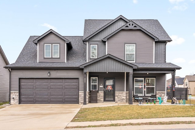 craftsman-style home featuring a porch, a garage, and a front lawn