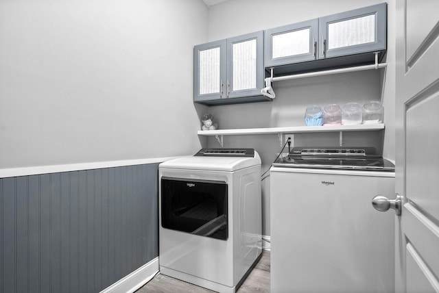 laundry area with light hardwood / wood-style floors and washing machine and clothes dryer