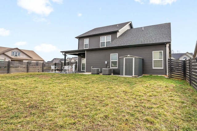 rear view of property with a storage shed, a patio area, central AC, and a lawn