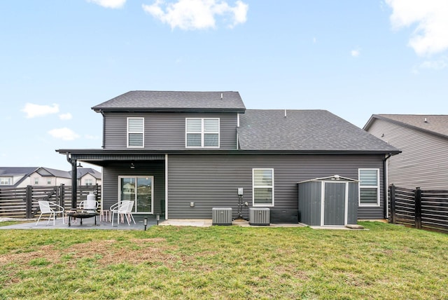 back of property with a shed, a yard, an outdoor fire pit, central AC unit, and a patio area