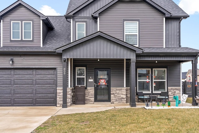 craftsman house with a garage, a porch, and a front yard