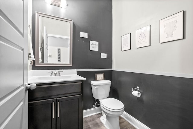 bathroom with vanity, toilet, and hardwood / wood-style floors