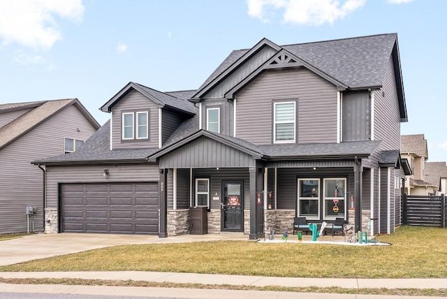 craftsman inspired home featuring a garage, a front lawn, and a porch