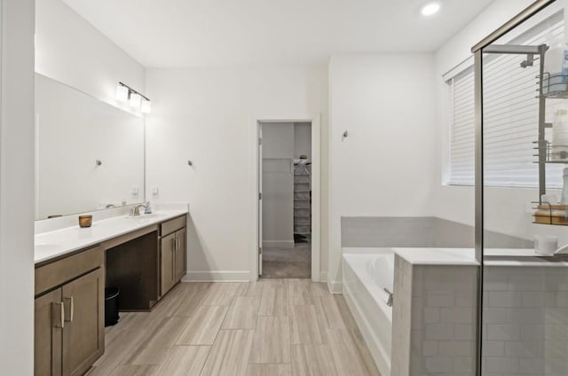 bathroom with vanity and a washtub