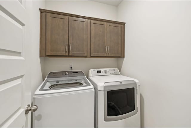 laundry room featuring cabinets and washer and clothes dryer