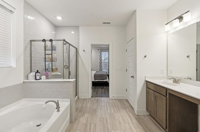 bathroom with vanity and independent shower and bath