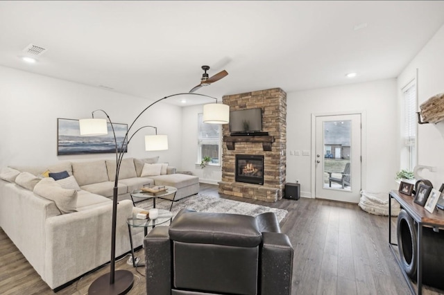 living room with a stone fireplace and hardwood / wood-style floors