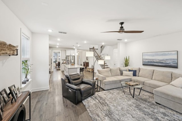 living room featuring hardwood / wood-style floors and ceiling fan