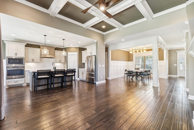 living room featuring beamed ceiling, coffered ceiling, dark wood-type flooring, and crown molding