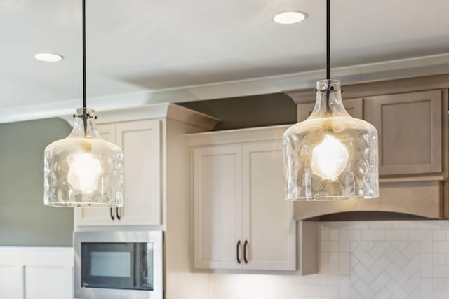 room details with stainless steel microwave, hanging light fixtures, and a fireplace